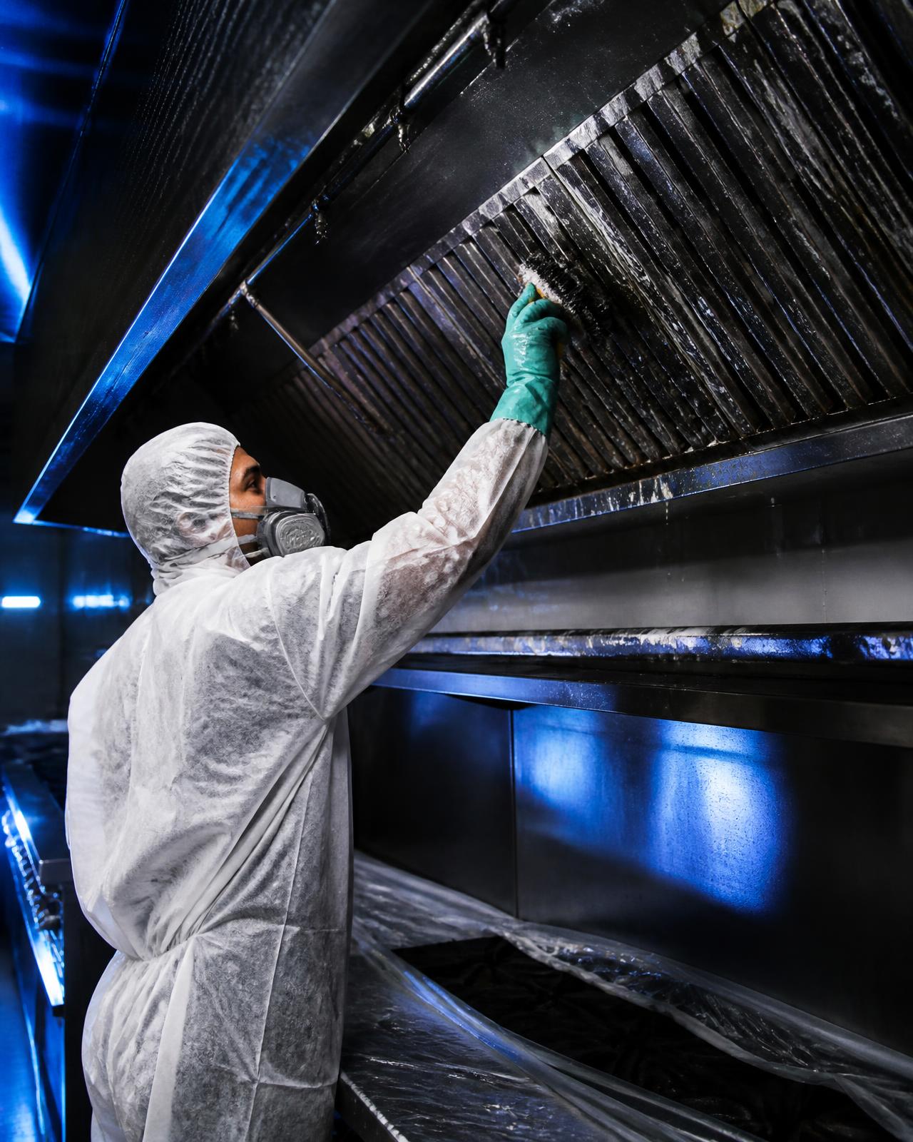 Técnico da SOV Clean higienizando coifa industrial de aço inox